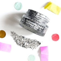  Silver glitter gel face makeup product with shimmering, sparkling texture.
