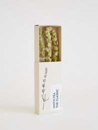 A small, classic tea box containing green tea leaves. The box has a simple, minimalist design with a hand-drawn floral illustration and the product name "The Classic | Mini" printed on it.