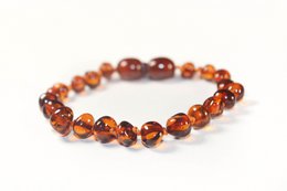 Amber-colored bracelet with round and oval-shaped beads, suitable for pregnancy or baby wear.