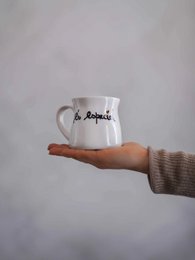  A white ceramic mug with the text "És especial" printed on it. The mug is being held in a hand against a plain background.