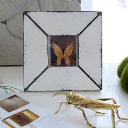 Vintage-style white photo frame with a stained glass design featuring a golden winged creature.