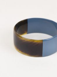 A large, flat, gray-blue lacquered bracelet made of horn in size L.