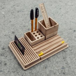 Wooden desk organizer with compartments for pens, pencils, and other office supplies. Rectangular shape with a natural wood finish.