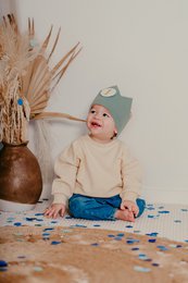 Green and white crown-shaped hair accessory with gold glitter number 1 in the center. Made of soft, textured material. Suitable for kids' birthday celebrations or parties.