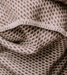  Large brown woolen blanket or throw with a textured knit pattern.