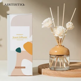 A glass reed diffuser with a wooden base, containing white floral accents and a glass bottle. The product is labeled as "Hotel Aroma 100 ml fiber stick Reed Diffuser" and is categorized as a Reed Diffuser.