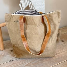 Vintage-style beige canvas tote bag with a simple design and minimal branding. Suitable for everyday use as a shoulder bag or shopping bag.
