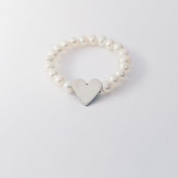  A pearl ring with a heart-shaped charm. The ring features a row of white pearls and a silver or gold heart-shaped charm. Available in multiple sizes.