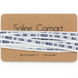 A pair of blue charm bracelet laces with the text "ALL I NEED IS YOU" printed on them.