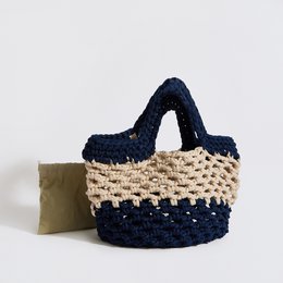 Crocheted beach bag in terracotta, creme, and mocha colors with a textured pattern.