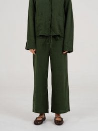 Green linen pants with a relaxed, wide-leg silhouette. Made from a soft, breathable linen blend fabric in a deep forest green color.