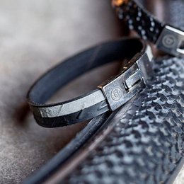  Black and silver metal cuff bracelet with textured design.
