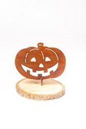 A carved pumpkin-shaped garden sculpture with a smiling jack-o'-lantern face and thorns protruding from the top.