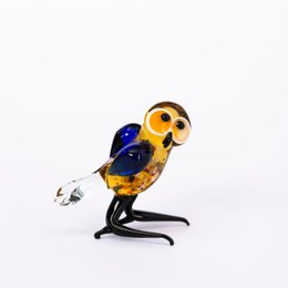 Glass owl statue with large eyes in blue and yellow colors.