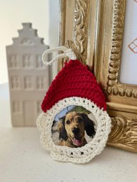  'Christmas Ornaments Handmade - Special Edition: Crocheted ornaments in various colors and designs, including red and green hats, red and white balls with strings, and round ornaments with a photo frame center.'
