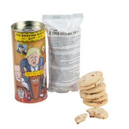 The Briefing Biscuit, an Eton Mess, is a cookie product packaged in a tin with a colorful, cartoon-style illustration on the front. The tin contains a stack of round, light-colored cookies.