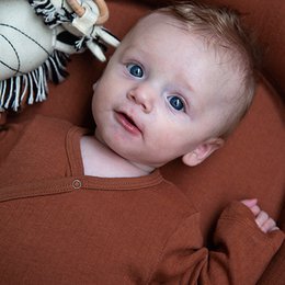 Long sleeve bodysuit for infants in amber brown color, available in sizes 0-12 months.
