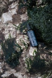 Magnesium-infused body gel in a blue glass bottle, designed for massage and relaxation.