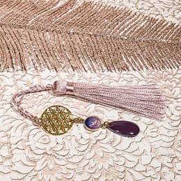 Colorful, decorative bookmarks with tassels, sequins, and floral elements. The bookmarks feature a variety of colors including red, yellow, and purple, and incorporate natural materials like flowers and beads.