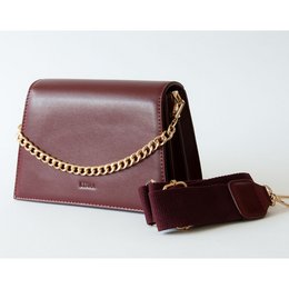 Burgundy leather shoulder bag with gold chain strap and flap closure.
