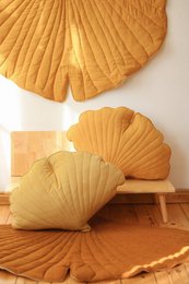 Soft, plush velvet cushion in a ginkgo leaf shape, featuring a warm honey color palette.