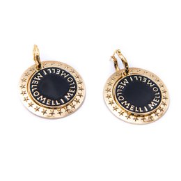 Gold-coated coin-shaped stud earrings with black enamel detailing and a decorative border.
