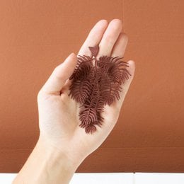 Burgundy feathered brooch with embroidered knight's plume fern design.