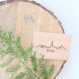 Skyline map of Dutch cities, featuring Tilburg, Breda, Nijmegen, Amsterdam, Eindhoven, Almere, Rotterdam, Groningen, and The Hague. Wooden cards with city silhouettes.