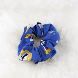 A blue and yellow patterned scrunchie with a soft, textured fabric.
