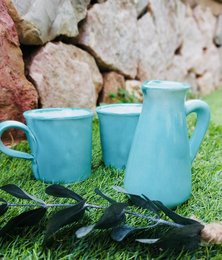 Handmade ceramic gift set with turquoise mugs and pitcher, featuring a simple, minimalist design.