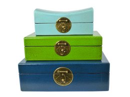 Set of decorative boxes in various shades of green, blue, and mint. The boxes feature brass-colored latches and are stacked in a tiered arrangement.