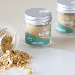 Organic ginger powder in a glass jar labeled "Nomie Gingembre". The powder has a light brown color and appears to be finely ground.