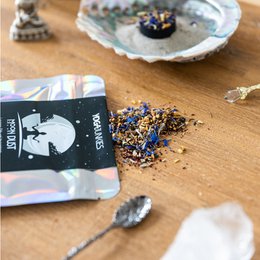 Loose incense mix with moon dust and other natural ingredients, packaged in a black and holographic pouch.