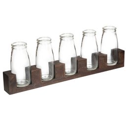 A set of 5 clear glass vases with wooden stands, arranged in a row on a wooden surface. The vases contain a variety of colorful flowers, including orange, purple, and white blooms.