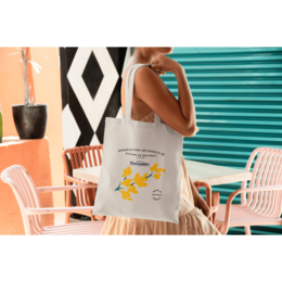  Cream-colored tote bag with a yellow butterfly graphic and the text "Spread your wings" printed on it. The bag appears to be made of a durable, canvas-like material and has a simple, minimalist design.