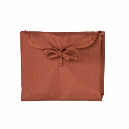 Warm rust-colored changing mat made of soft, durable fabric with a bow detail.