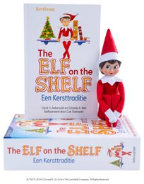Red and green plush elf doll with Christmas tree and book titled "The Elf on the Shelf: Een Kersttraditie" (The Elf on the Shelf: A Christmas Tradition)