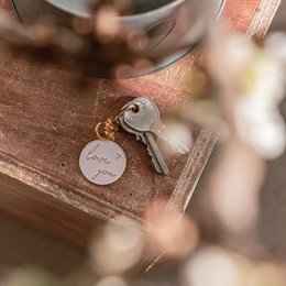  Keychain with "Love You" text, metal material, round shape, hanging on a wall.