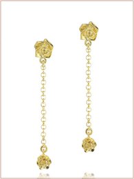  Gold and silver drop earrings with floral designs and dangling chains.