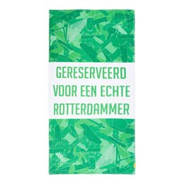 A green beach towel with the text "GERESERVEERD VOOR EEN ECHTE ROTTERDAMMER" (Reserved for a true Rotterdammer) printed on it. The towel features a vibrant, abstract green pattern.
