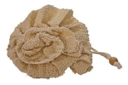 A natural sisal flower-shaped sponge. The sponge has a beige, textured, and floral appearance.