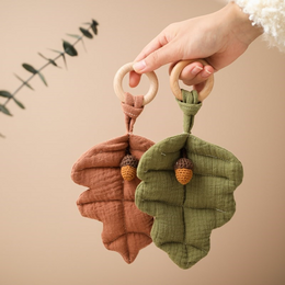 Soft, plush teether in the shape of acorns in brown and green colors, perfect for soothing baby's gums during teething.