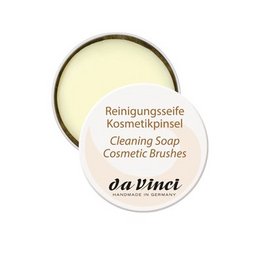 Cleaning soap in a metal box, suitable for makeup brushes. The soap is round and has a pale yellow color.