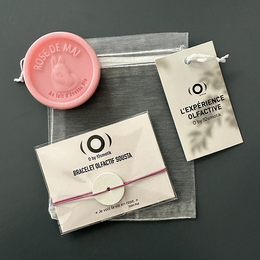  A rose-scented olfactory bracelet and soap pouch set, made of natural materials. The set includes a pink soap and a clear pouch with a ribbon closure.
