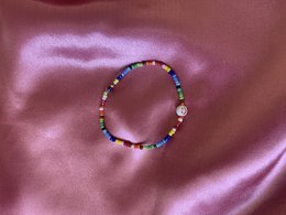 Multicolored beaded bracelet with smiley face charm, available in various sizes and colors.