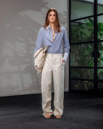 Creased white trousers with a relaxed, straight-leg fit.