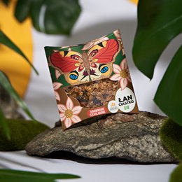 Colorful butterfly-shaped cookie package containing organic cranberry and chocolate cookies. The package features a vibrant, nature-inspired design with floral and butterfly motifs.