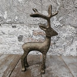  A decorative reindeer figurine made of metal, measuring approximately 11 x 6 x 21 cm. The reindeer has a rustic, antique-like appearance, with detailed antlers and a textured surface.