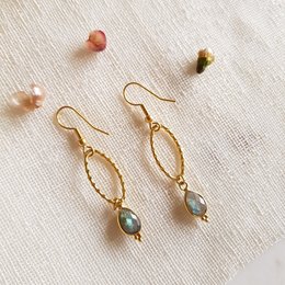 Elegant gold-tone drop earrings featuring a labradorite gemstone. The earrings have a unique twisted wire design and a delicate, feminine look.