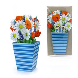 A vibrant bouquet of colorful flowers, including daisies and tulips, arranged in a striped blue and white vase. The flowers create a cheerful and eye-catching display.